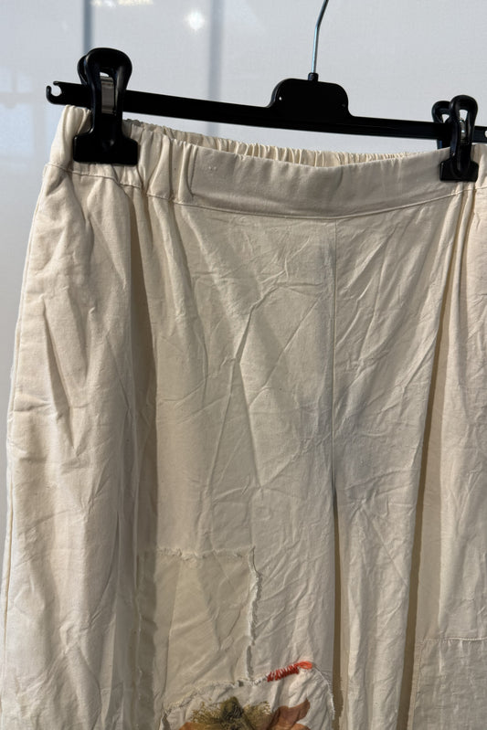 Pantalone écru con applicazioni floreali e inserti crochet