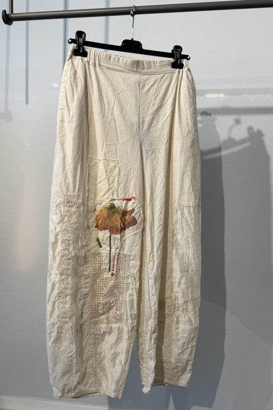 Pantalone écru con applicazioni floreali e inserti crochet