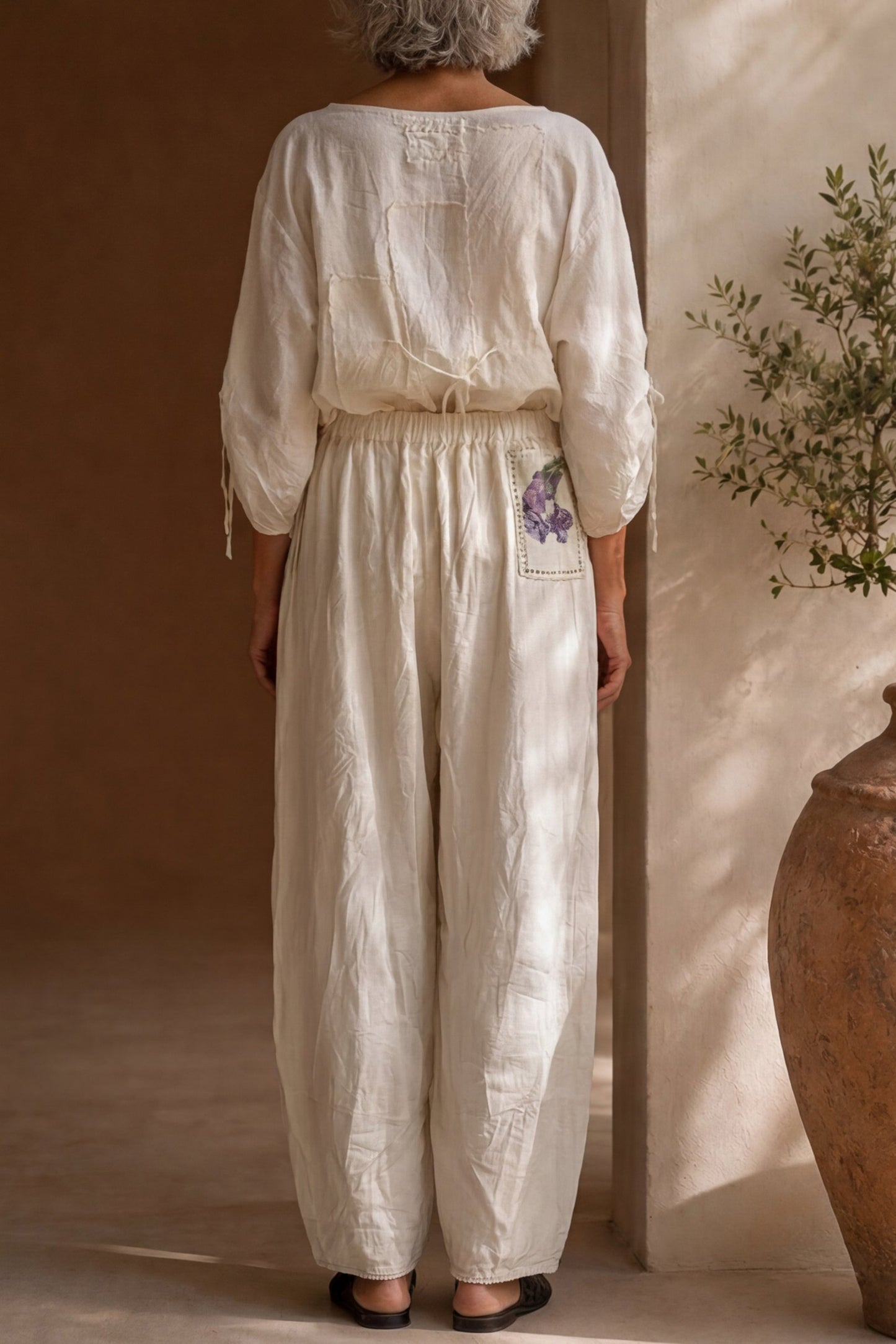 Pantalone écru con applicazioni floreali e inserti crochet